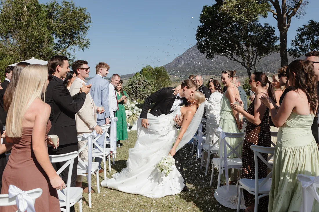 Alaska and Billy walking back down the aisle through confetti as guests celebrate
