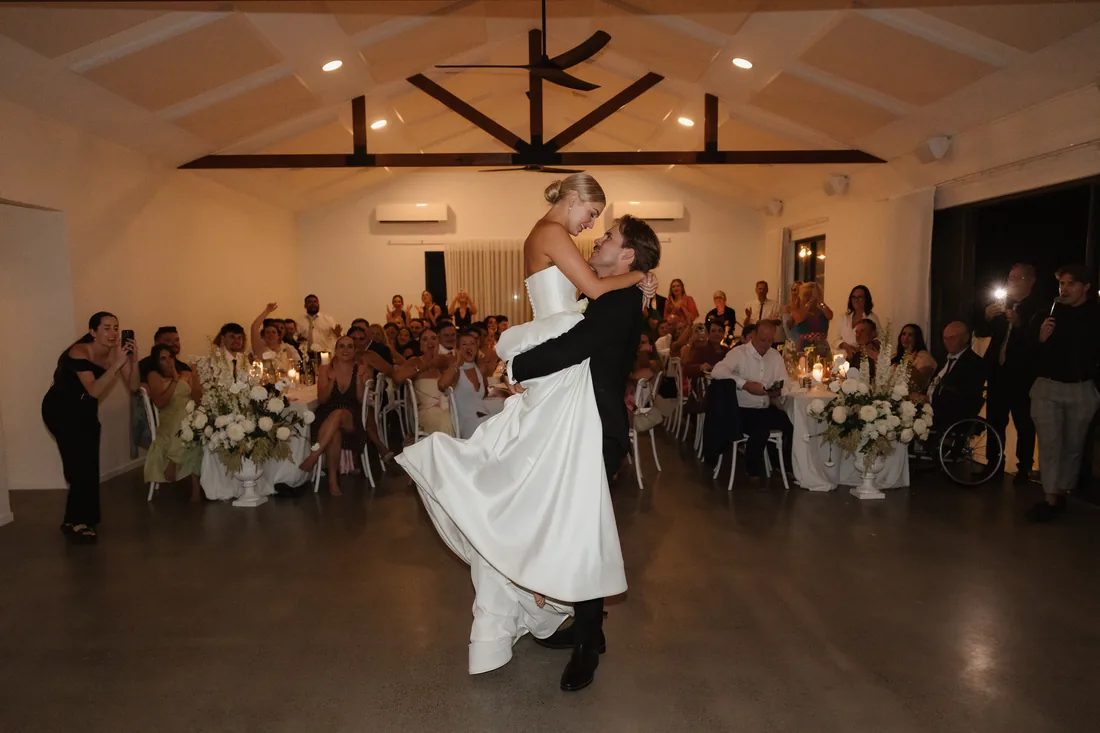 Bride and groom sharing a dance as guests applaud in the reception room