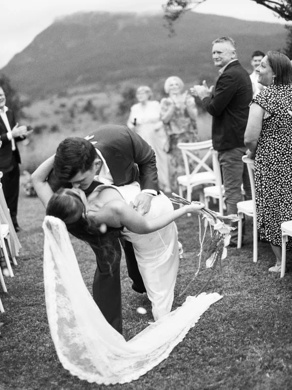 Alex and Will embracing at the end of the aisle as guests applaud