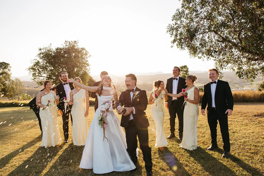 Bridal party celebrating with confetti and laughter at golden hour