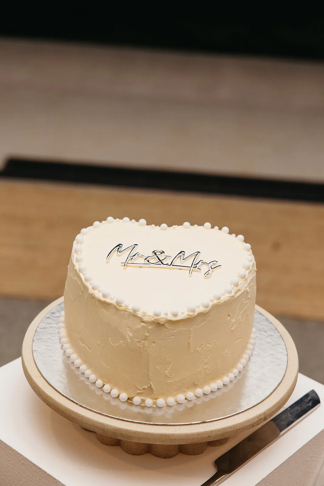 Heart-shaped wedding cake with a Mr and Mrs topper and pearl piping