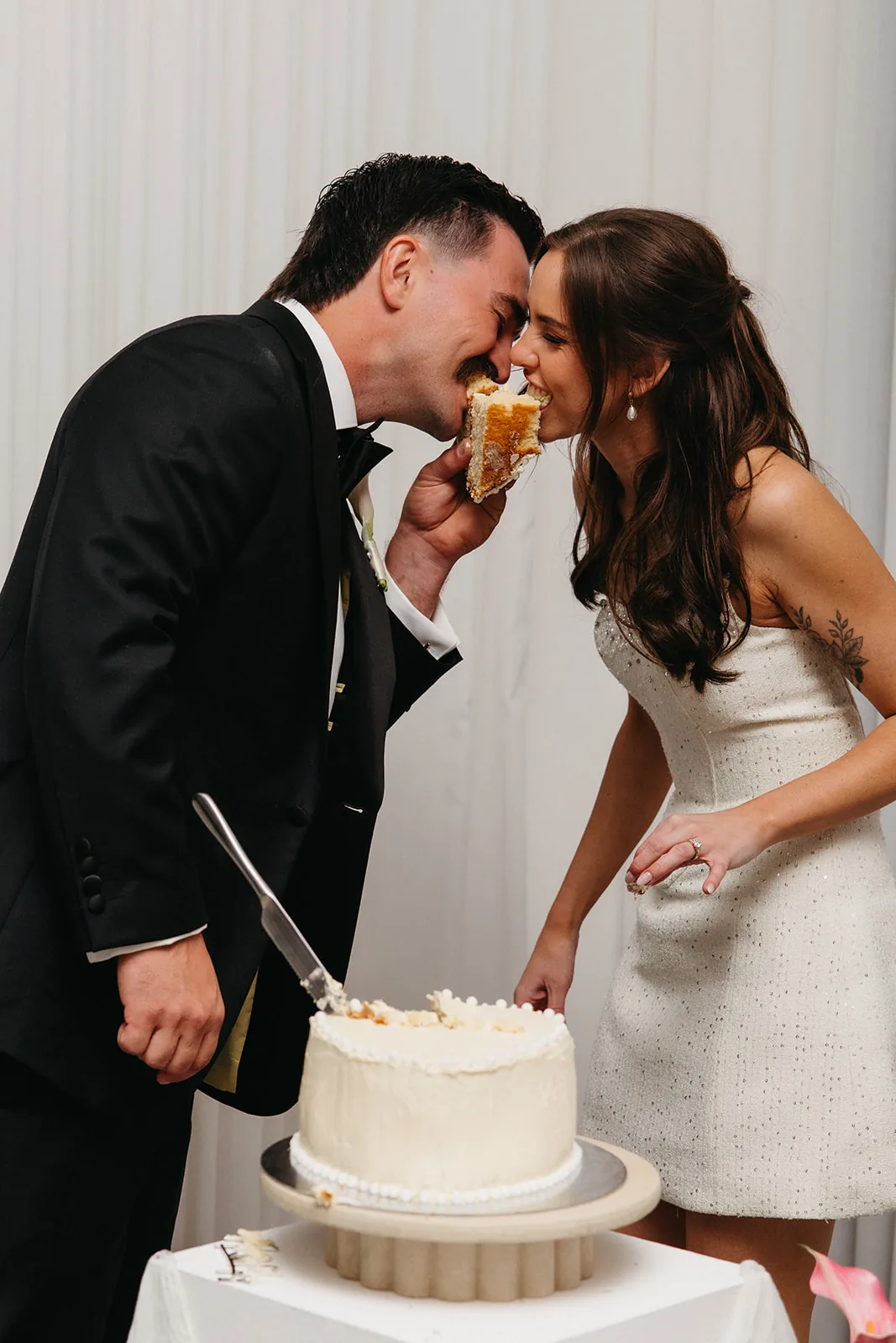 Ally and Braydon feeding each other cake, foreheads touching