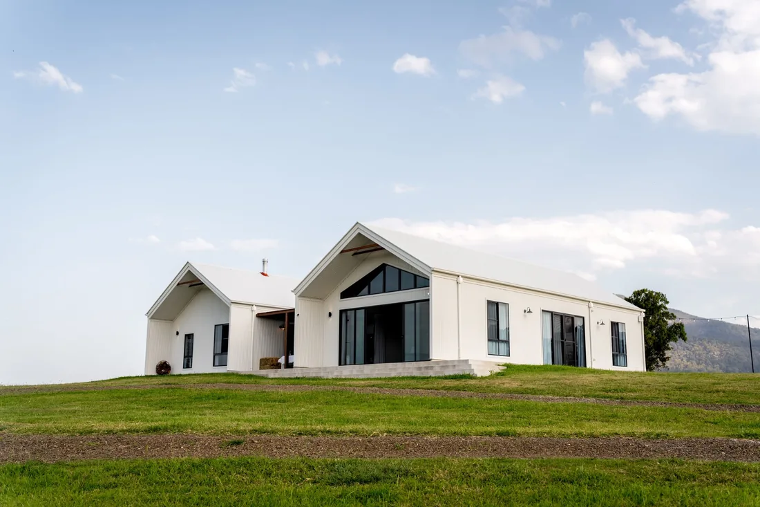 Exterior of the white farmhouse-style reception venue at Maroon Hill Estate