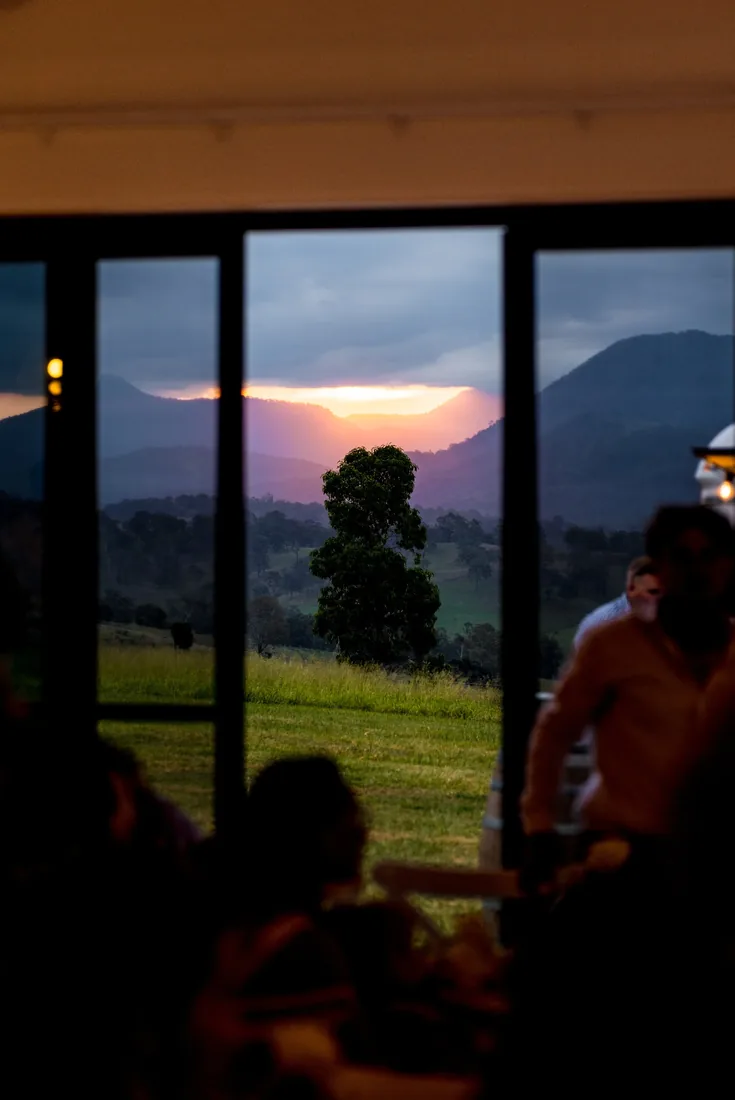 Sunset view of the mountains through the reception windows as guests dine