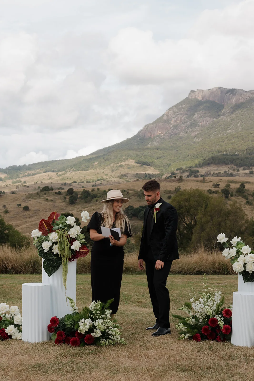 Celebrant chatting with the groom before the ceremony, floral pillars either side