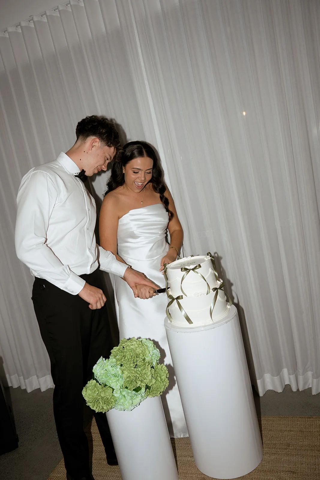 Jodi and Frank cutting their two-tiered wedding cake together
