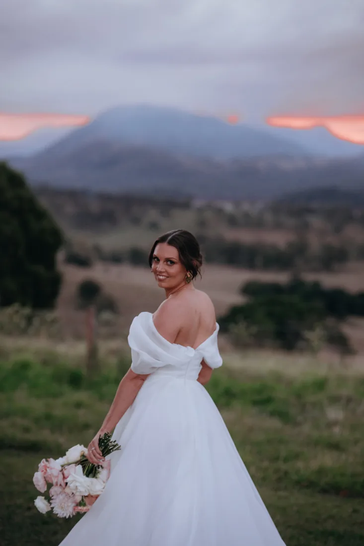 Jorjia looking back over her shoulder at golden hour with the mountains behind her
