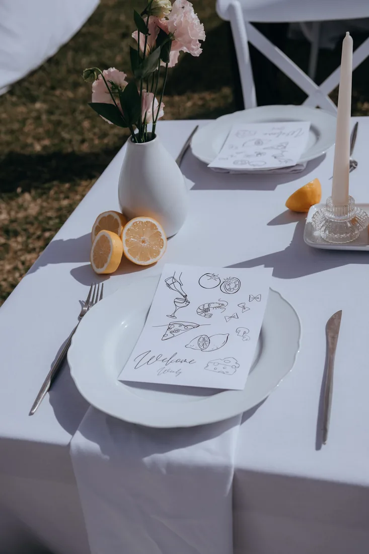 Place setting with hand-drawn menu card, lemons and candles at Maroon Hill Estate