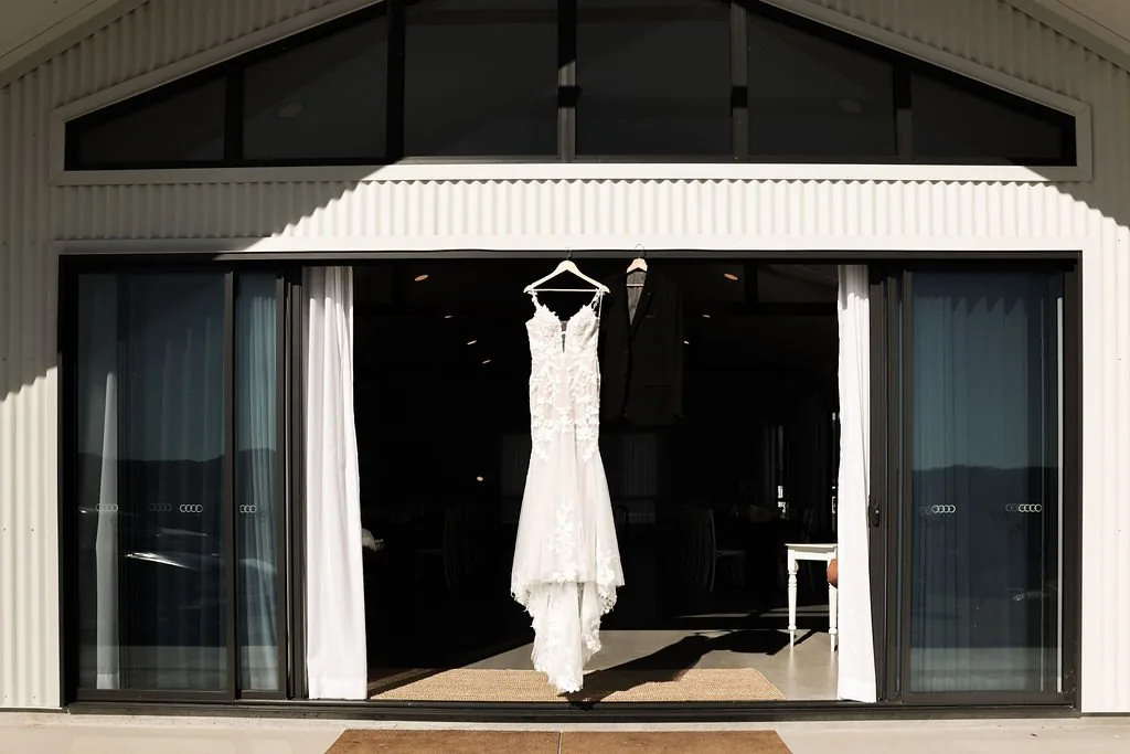 Wedding dress hanging in the venue's entrance doorway with mountains visible behind