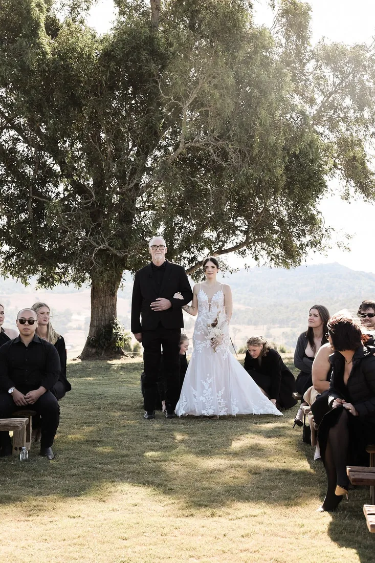Black and white photo of Kate and Jacob exchanging vows under a large tree