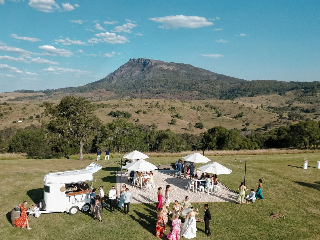 Aerial view of the ceremony setup with a horse float catering van and mountains behind