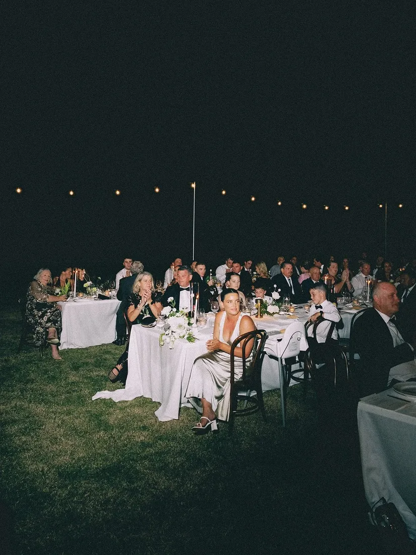 Guests seated at candlelit tables during the reception at night