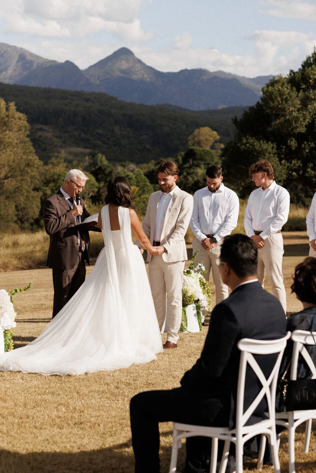 Sarah reading her vows to Hamish as groomsmen and the celebrant look on