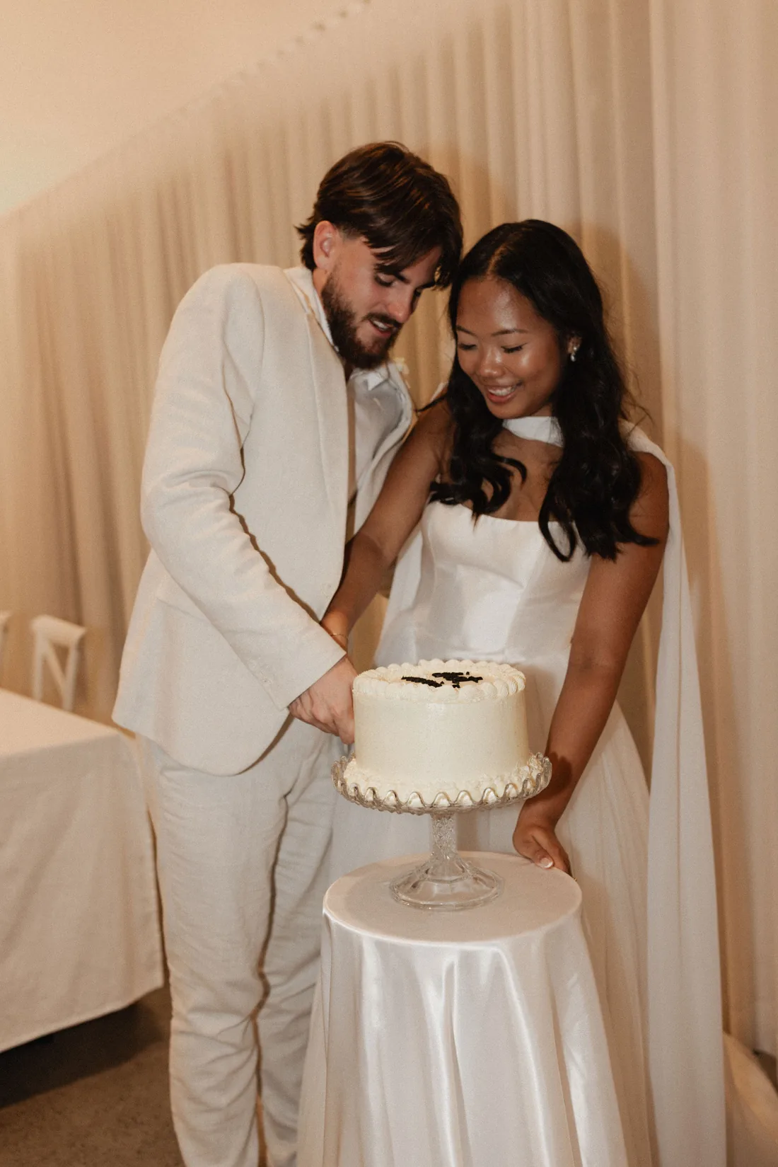 Hamish and Sarah cutting their wedding cake together