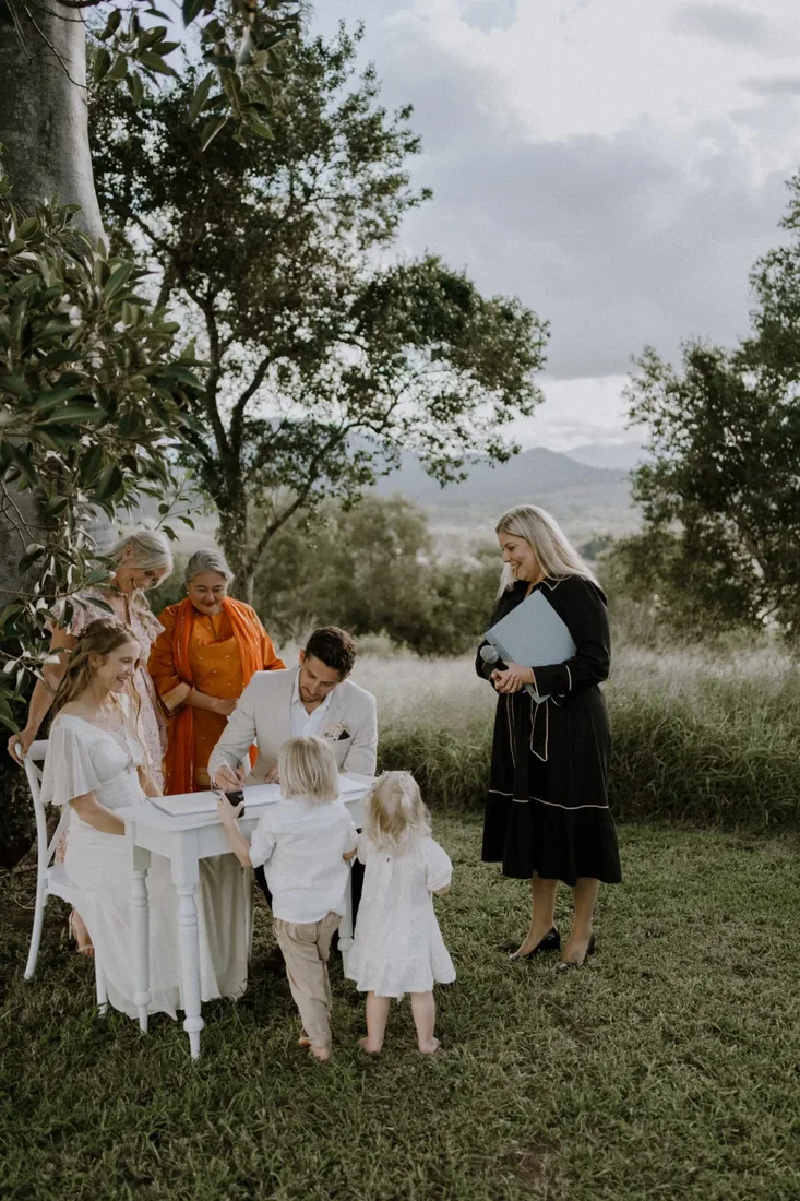 Sarah and Rhys signing the register surrounded by family