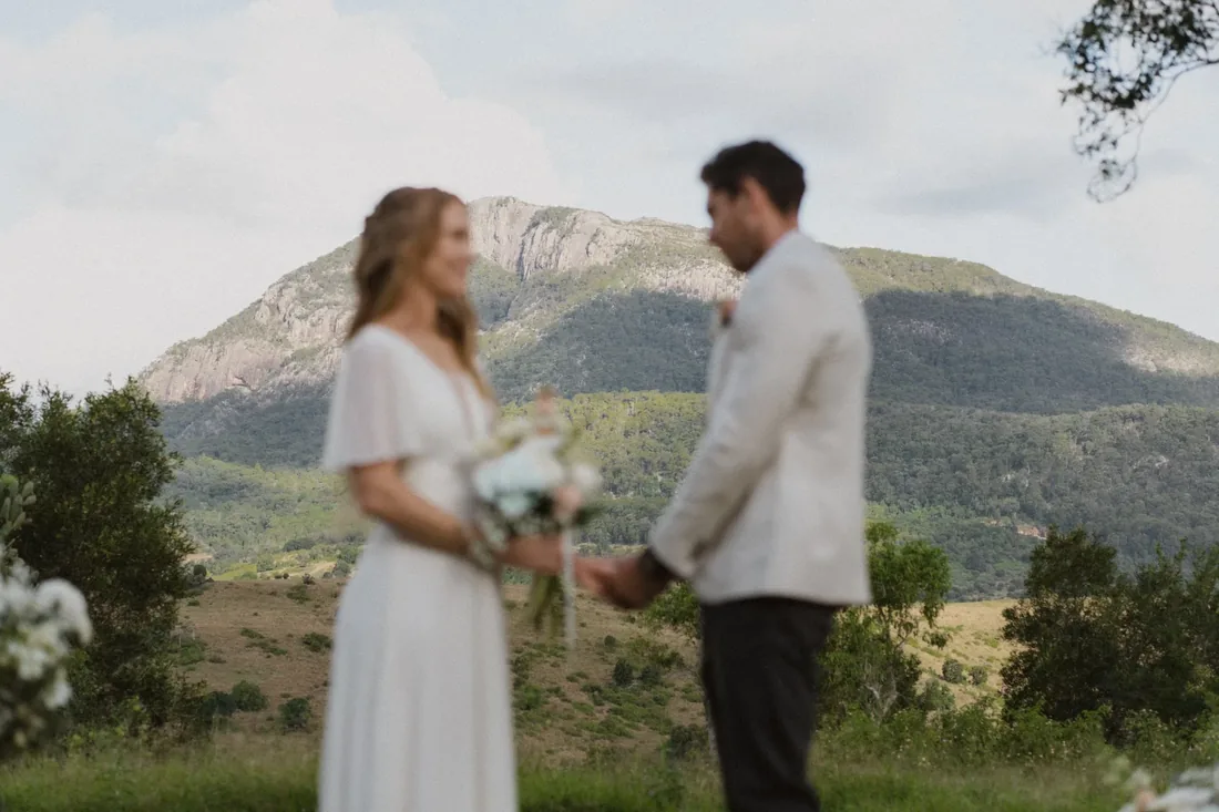 Sarah and Rhys during their first look moment with Mount Maroon behind them