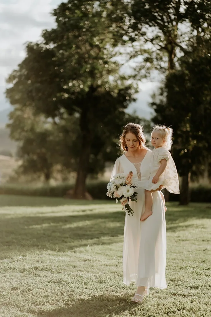 Sarah carrying her daughter across the lawn at Maroon Hill Estate