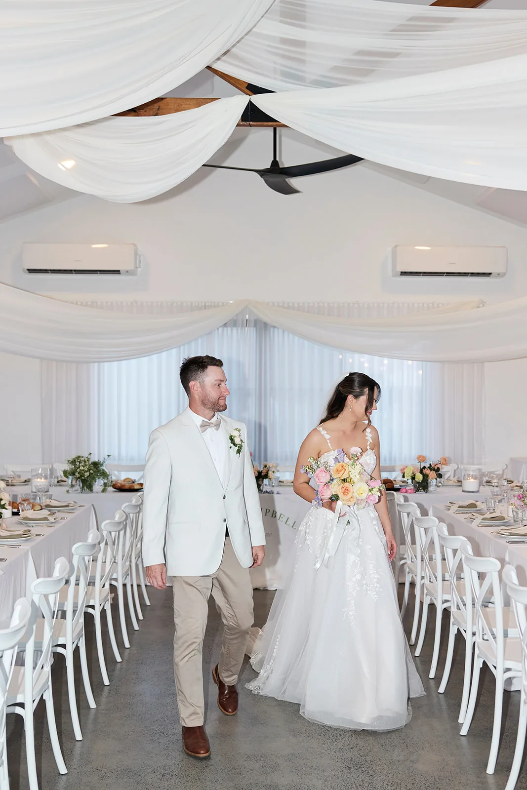 Taylor and Jayden walking into the draped reception room together