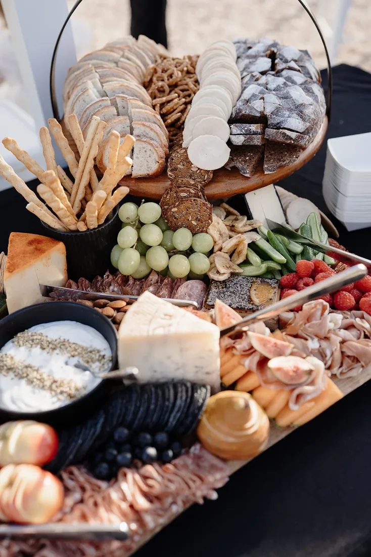 Close-up of a grazing table with crackers, grapes, dried fruit and charcuterie