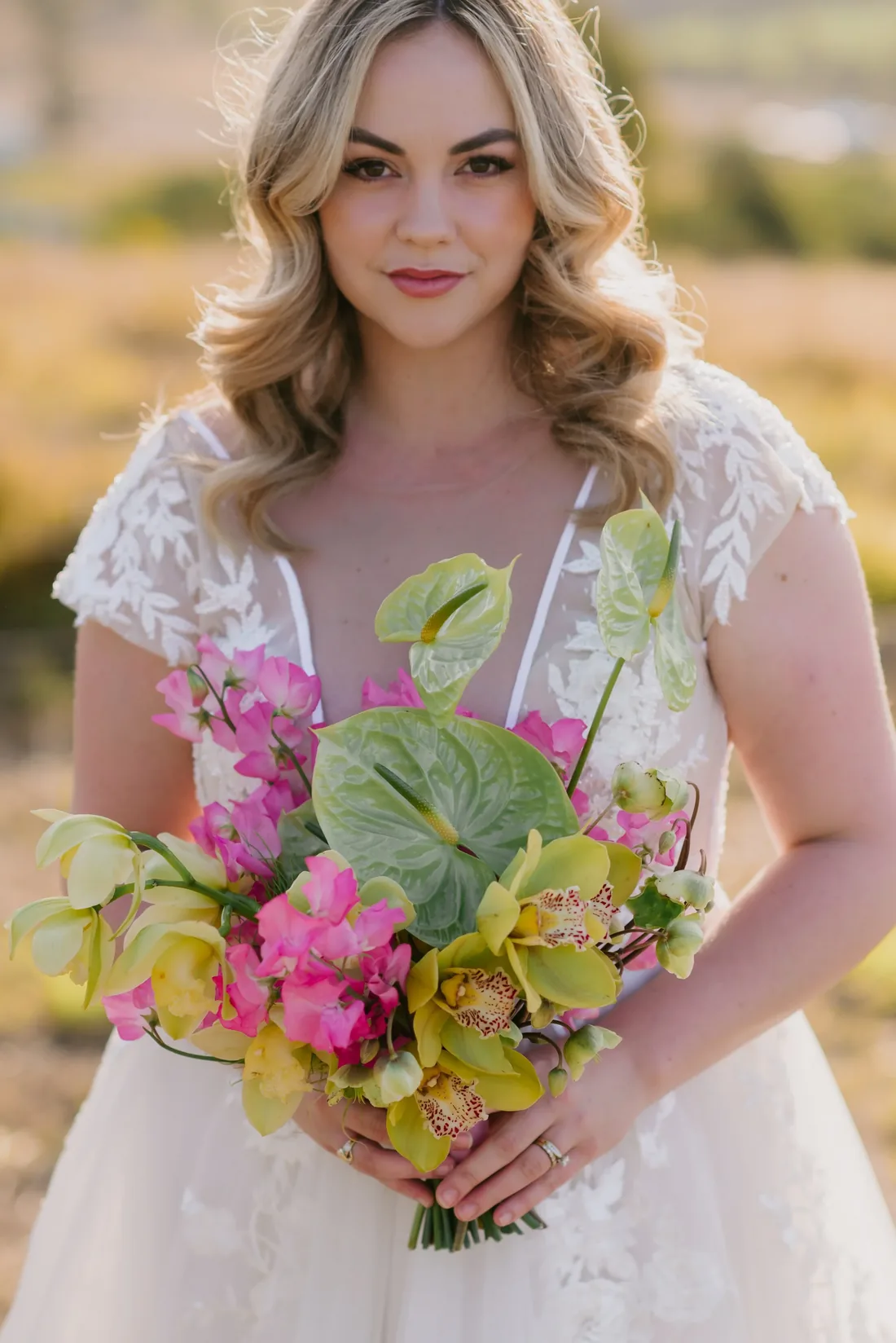 Close-up of a bride holding a tropical bouquet of anthurium, orchids and bougainvillea